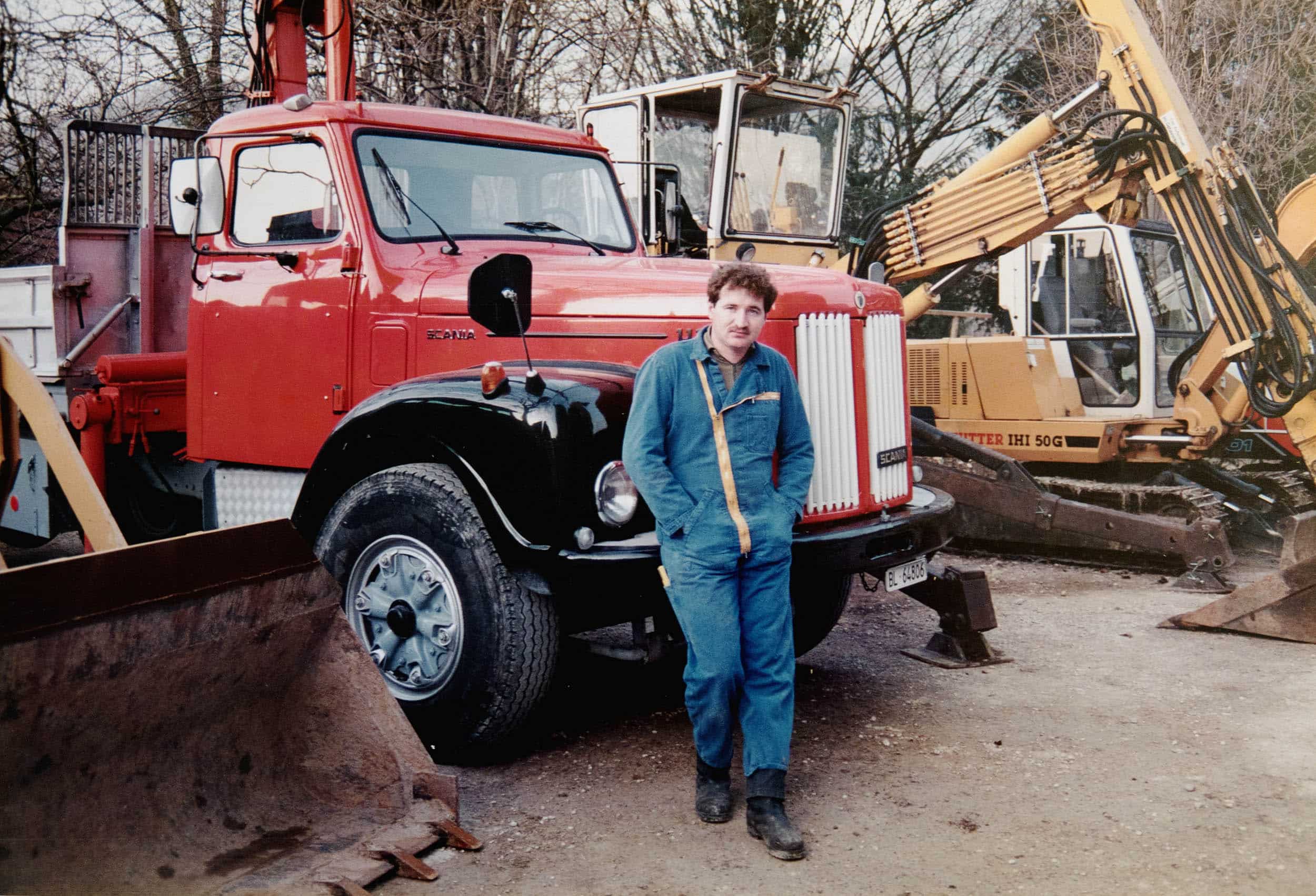 Über uns: Urs Jakob vor einem roten Fahrzeug bei der Gründung der eigenen Tiefbau-Firma im Jahr 1991